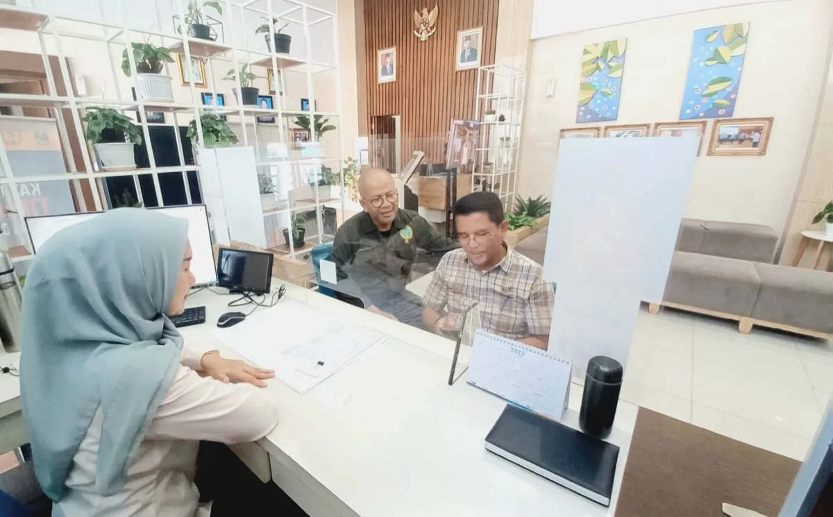 Petugas front office melayani dua tamu