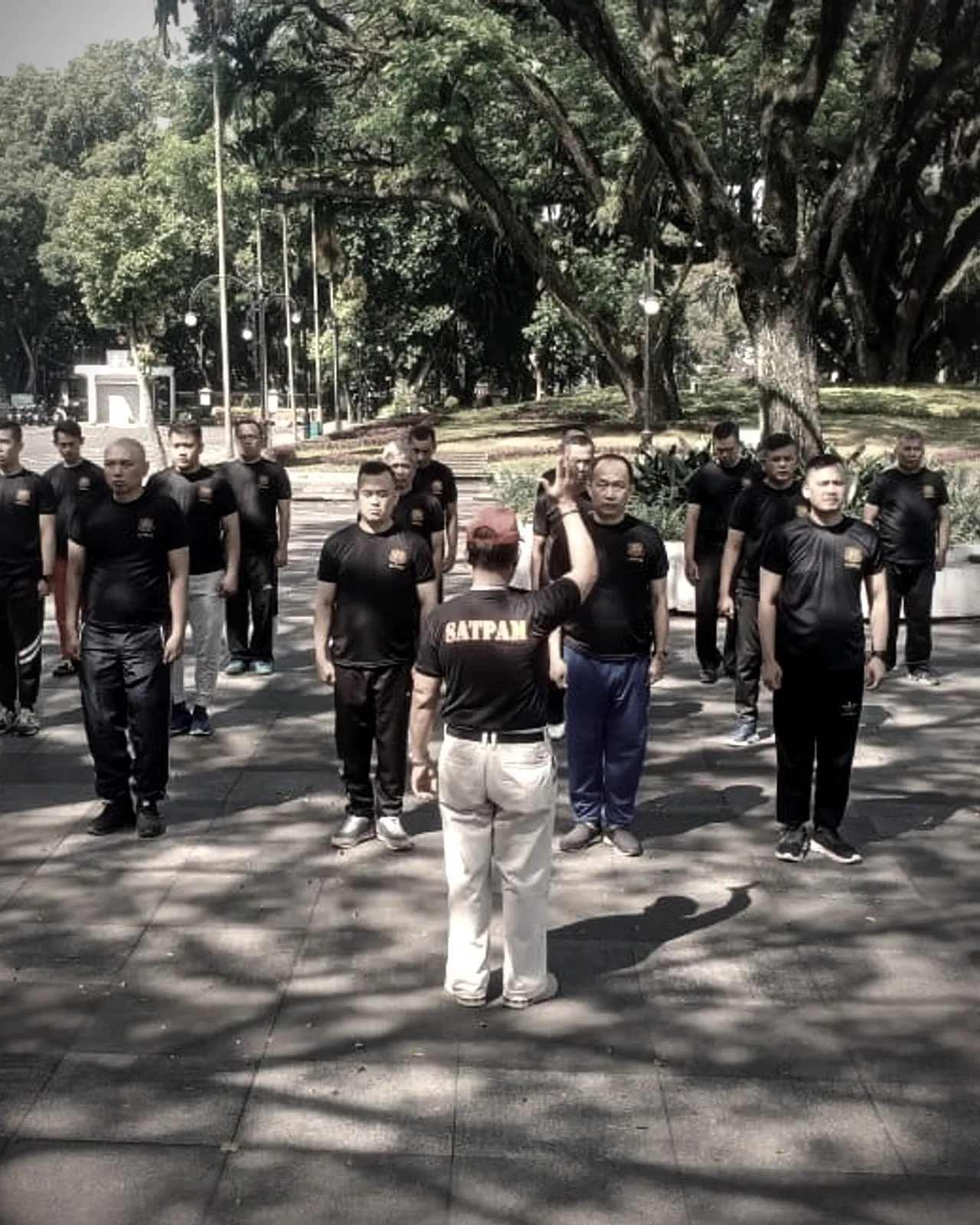 Komandan satpam memimpin latihan baris-berbaris anggota keamanan