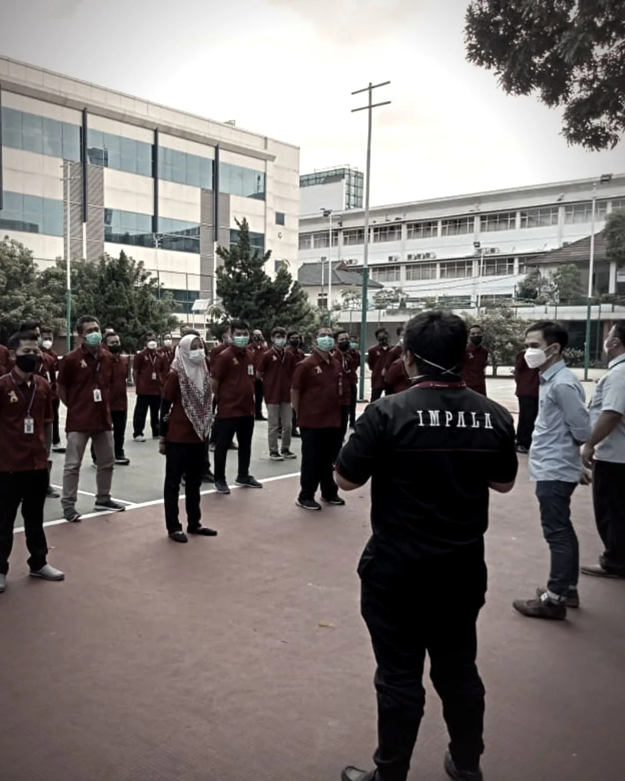 Koordinator Impala memberi arahan kepada tim kebersihan berseragam merah